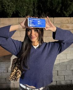 a woman holding up a cell phone to her head