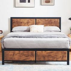 a bed with two drawers underneath it in a bedroom next to a table and lamp