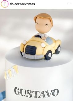 a cake with a boy driving a toy car on it's top and the words gustavo written in spanish