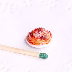 a small plate with some food on it next to a wooden spoon and a fork