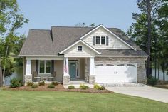 a house with a flag on the front lawn and two garages in front of it