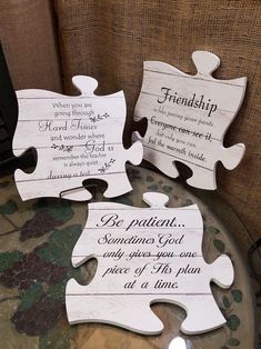 two pieces of puzzle sitting on top of a table next to each other with words written on them