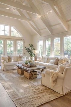 a living room filled with white furniture and lots of windows on top of the ceiling