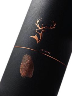 a close up of a wine bottle with a fingerprint on the label and a deer's head