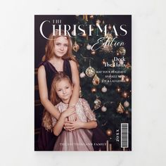 a magazine cover with two girls hugging each other in front of a christmas tree and ornaments