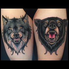 two black and grey wolf tattoos on both thighs, one with an open mouth