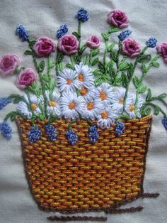 a basket filled with lots of white and pink flowers on top of a table cloth