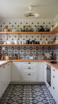 a kitchen with white cabinets and black and white tile on the walls, flooring and counters