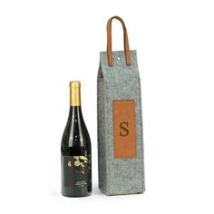 a bottle of wine sitting next to a bag with the letter s on it's side