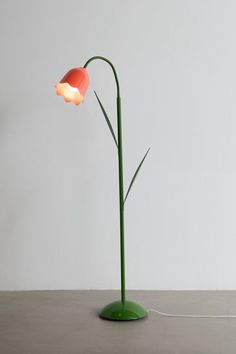 a lamp that is sitting on top of a table in front of a white wall