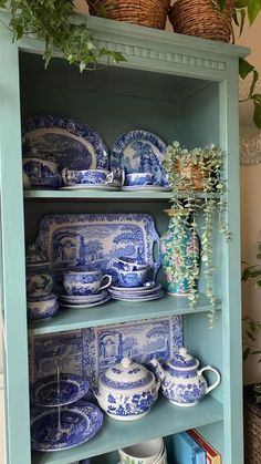 an old china cabinet with blue and white dishes