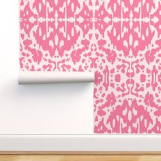 pink and white wallpaper with an abstract design on it's side, next to a wooden floor