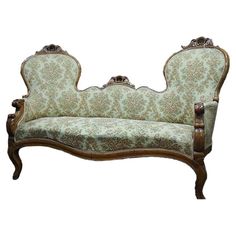 an old style couch with ornate carvings on the armrests and foot rests against a white background