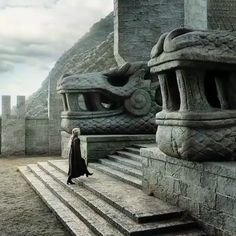 a woman is standing on some steps in front of an old building with dragon heads