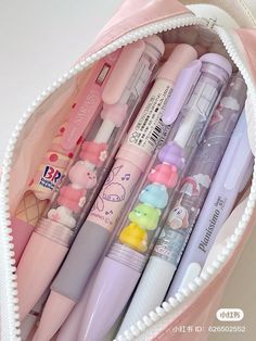 a pink bag filled with lots of different types of pens