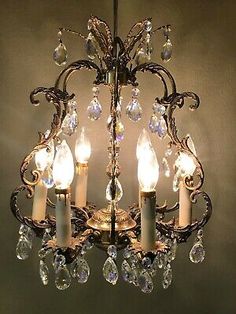 an antique chandelier with crystal drops hanging from the ceiling