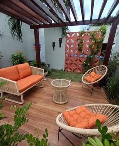 an outdoor living area with wicker furniture and potted plants on the decking