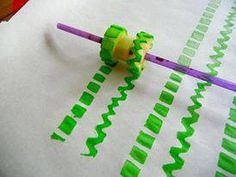 a pair of scissors cutting green and yellow strips out of paper with plastic straws