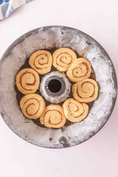 a metal bowl filled with cookies on top of a table