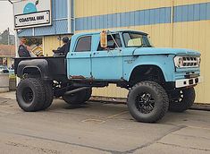 a blue truck parked in front of a building