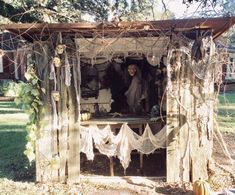 an outhouse decorated for halloween with decorations on the outside and in the front yard