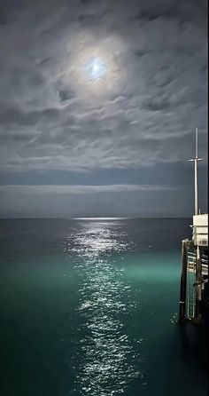 the full moon shines brightly over the ocean