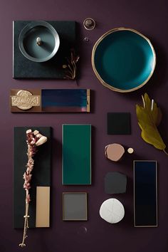 an assortment of different colors and shapes on a purple surface with gold accents, including plates