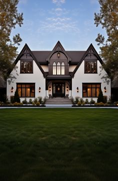 a large white house sitting on top of a lush green field