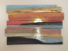 a piece of wood that has been cut into pieces with the sun setting in the background