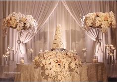 a wedding cake with flowers and candles on the table