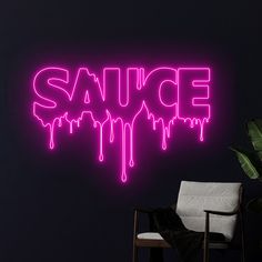 a neon sign that says sauce on the wall next to a chair and potted plant