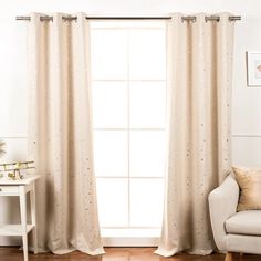 a living room with white furniture and curtains