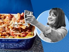 a woman holding up a glass in front of a casserole dish with lasagna