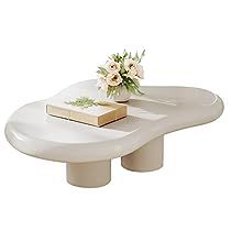 a white table with flowers on it and a book sitting on top of the table