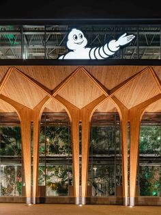 the entrance to an office building with wooden columns and arches on each side, lit up at night