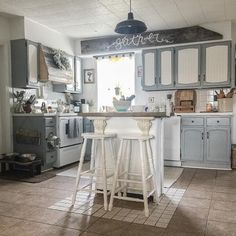 a kitchen with two stools in front of the counter and an open floor plan