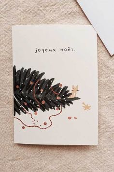 a christmas card with a pine tree on it and the words joyeux noel written in red