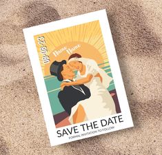 a save the date card sitting in the sand with a bride and groom on it