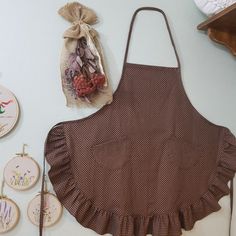 the apron is brown with white polka dots on it and there are several embroidered items