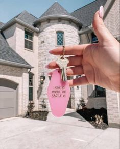 a person holding a pink key in front of a house