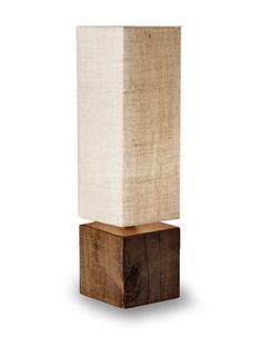 a wooden block with a white lamp on it's end and a linen shade over the top