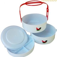 three white dishes with red handles and rooster decals on the lids, one is empty