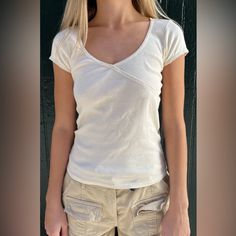 Cotton, Short Sleeve, Top With A Criss-Cross V-Neck And Scalloped Trim. Fabrics: 100% Cotton Measurements: 20" (51 Cm) Length, 12" (30 Cm) Bust Made In: China Starla Scalloped Trim Top, Fitted White Cotton V-neck Top, Fitted Cotton V-neck Top For Spring, Trendy Fitted Long Sleeve V-neck Top, Casual V-neck Fitted Top, Fitted Cotton V-neck Top With Short Sleeves, Fitted Cotton V-neck Top, Fitted V-neck Cotton Top, Fitted V-neck Short Sleeve Top For Summer