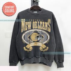 New Orleans Football Vintage Style Comfort Colors Sweatshirt,New Orleans Football Sweatshirt,Retro Saint Football shirt,Sunday Football ⭐𝐐𝐔𝐀𝐋𝐈𝐓𝐘: At Wonder Prints Era our brand believes in using the best materials to create our designs. Unlike many other shops using Gildan shirts that wear out quickly. We use luxury fabric and ink to make our products. Our designs are proudly Printed on Comfort Colors® tees/sweatshirts for that insanely soft, vintage look and feel and they meant to last. Vintage Letter Print Sweatshirt For Game Day, Vintage Fan Merchandise Graphic Sweatshirt, Vintage Graphic Print Sweatshirt For Fan Merchandise, Vintage Crew Neck Graphic Print Top, Vintage Graphic Print Crew Top, Vintage Crew Neck Top With Graphic Print, Vintage Long Sleeve Fan Merchandise Sweatshirt, Vintage Long Sleeve Sweatshirt For Fan Merchandise, Vintage Relaxed Fit Sweatshirt For Game Day