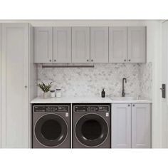 a washer and dryer in a white kitchen with cabinets on the wall behind them