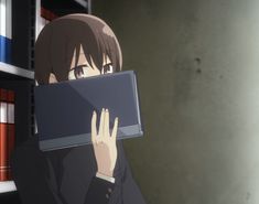 an anime character is hiding behind a bookcase