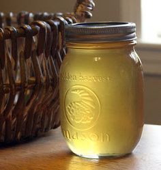 a glass jar sitting on top of a wooden table next to a wicker basket