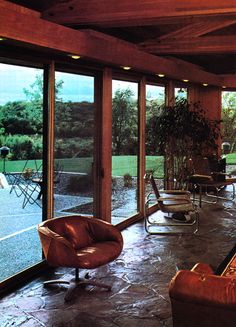 a living room filled with lots of furniture and large sliding glass doors that look out onto a lush green field