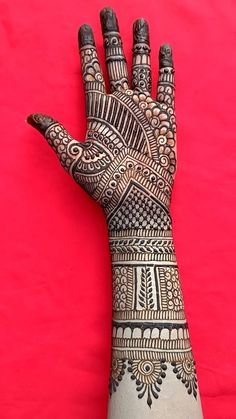 a henna tattoo on the palm of someone's hand, with red background