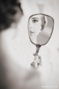 a woman looking at herself in the mirror